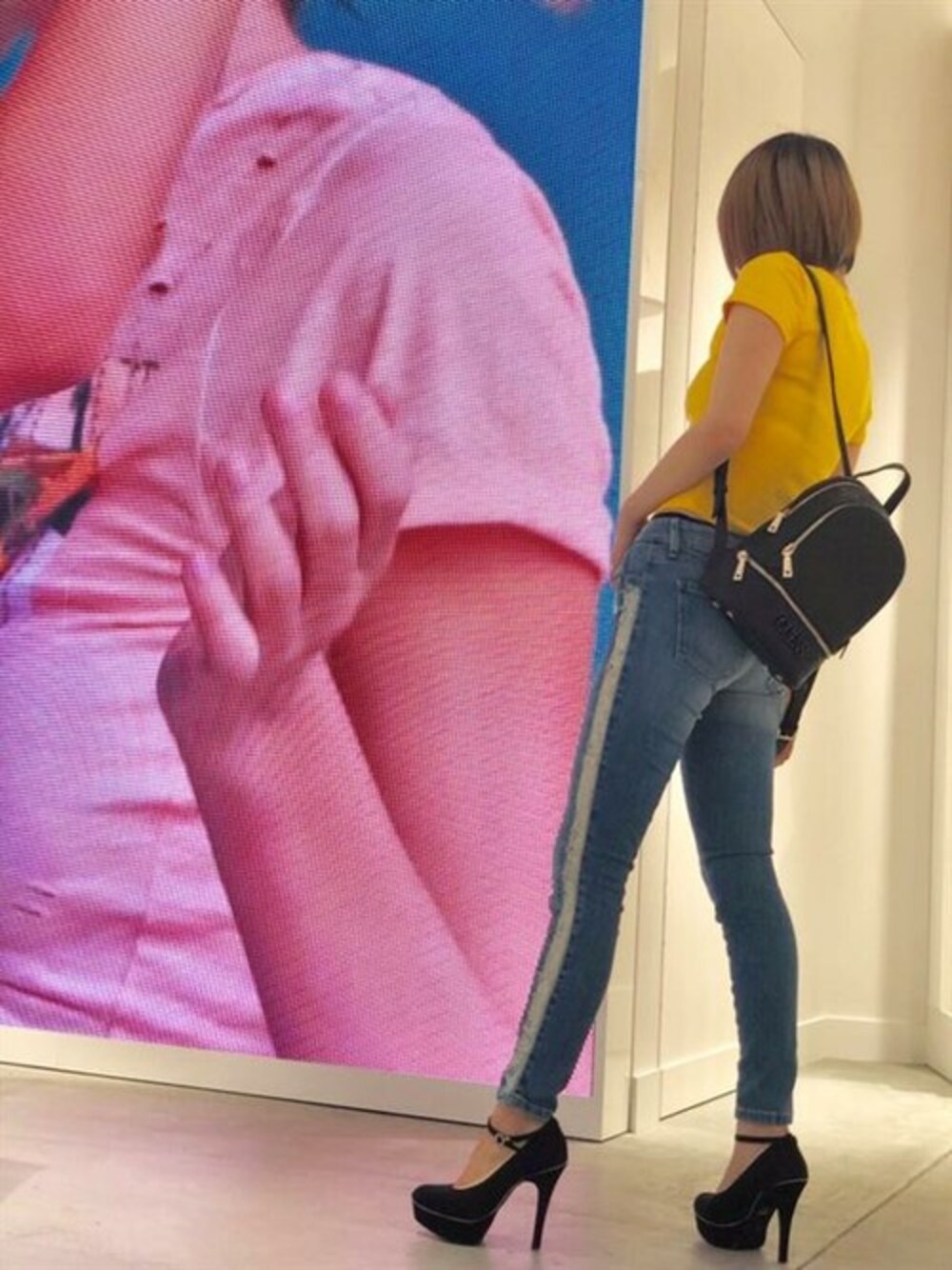 イエロー系のTシャツ/カットソー、ブルー系のデニムパンツ、ブラック系のバックパック/リュックを着用したレディースの夏コーディネートの1枚目の写真