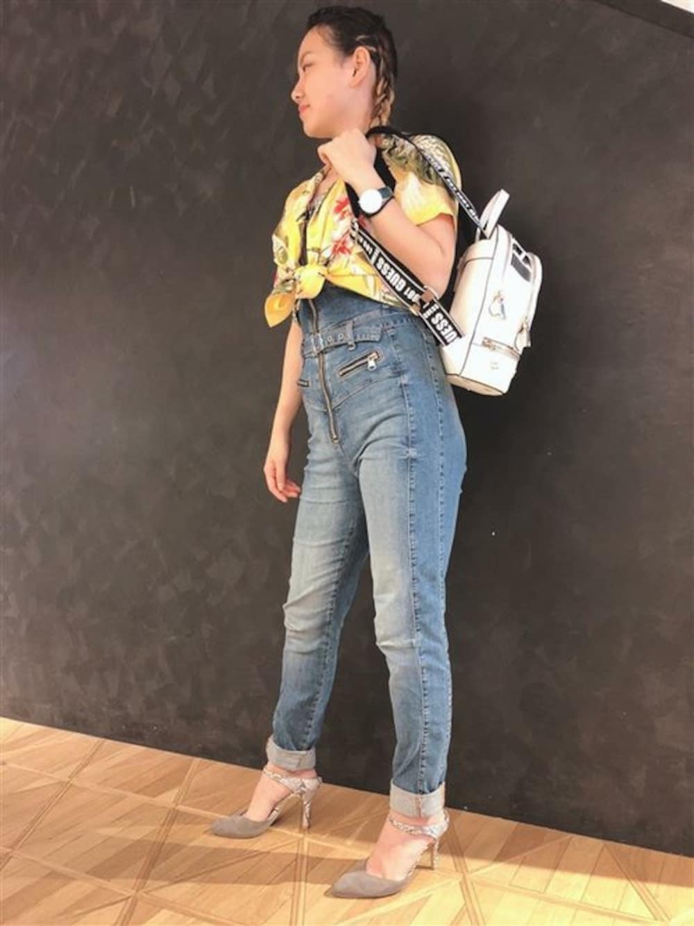 イエロー系のシャツ/ブラウス、ブルー系のサロペット/オーバーオール、ホワイト系のバックパック/リュックを着用したレディースの夏コーディネートの1枚目の写真