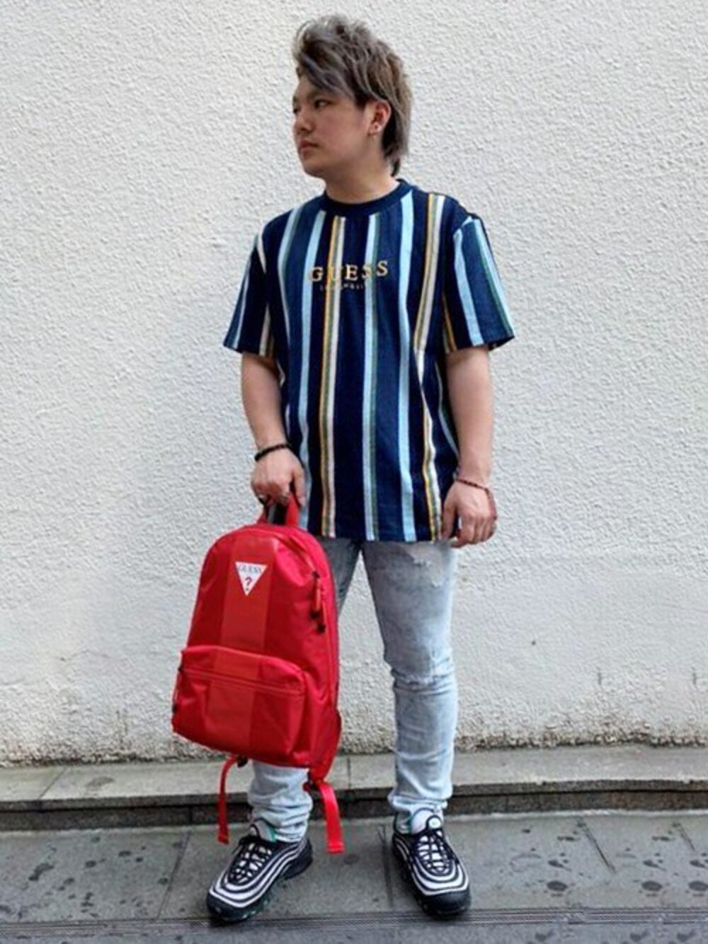 ブルー系のTシャツ/カットソー、ブルー系のデニムパンツ、レッド系のバックパック/リュックを着用したメンズの夏コーディネートの1枚目の写真