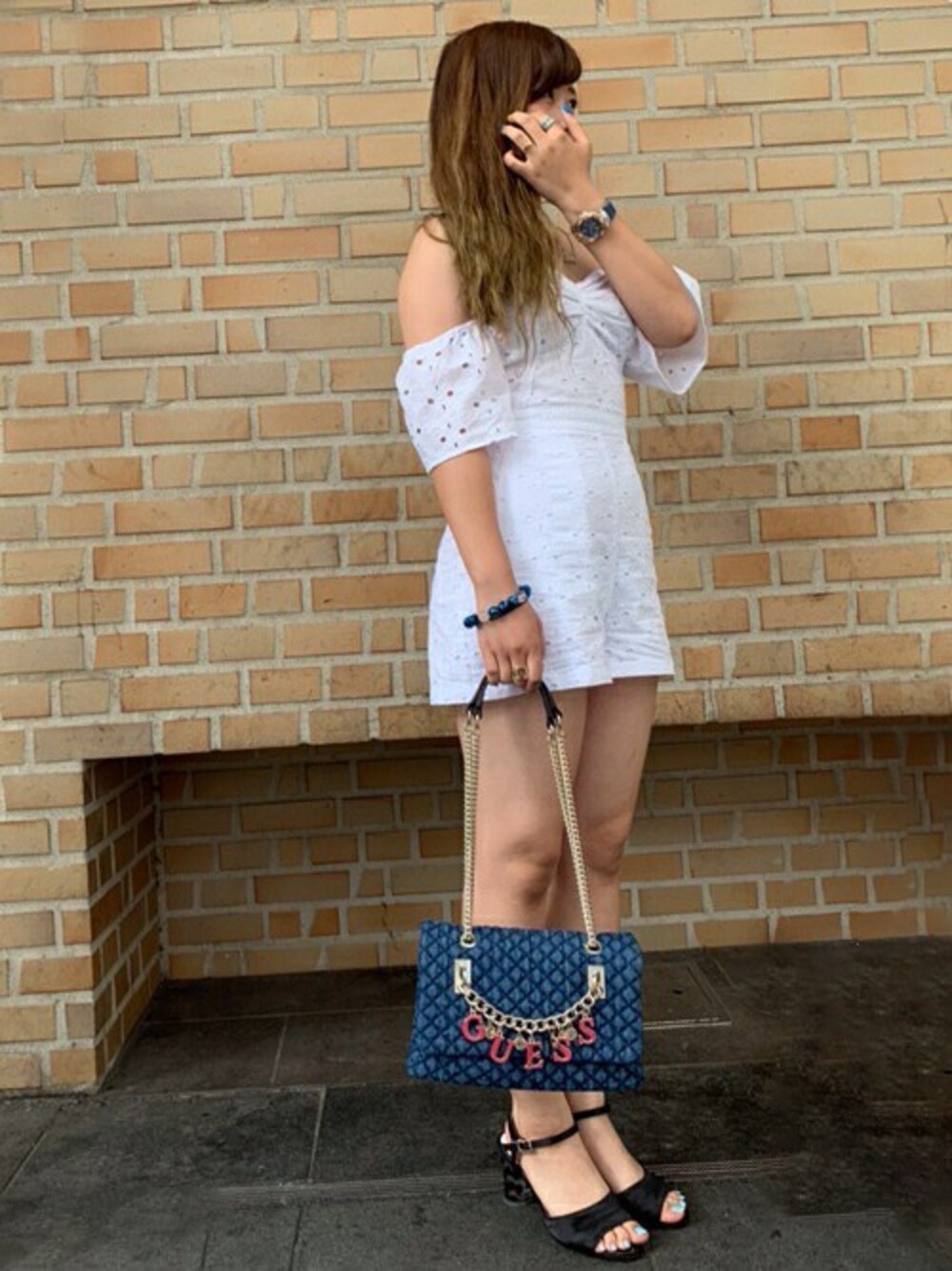 ブルー系のハンドバッグ、ホワイト系のサロペット/オーバーオールを着用したレディースの夏コーディネートの1枚目の写真