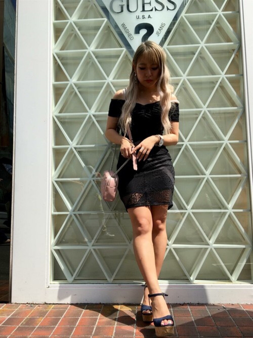 ピンク系のショルダーバッグ、ブラック系のワンピースを着用したレディースの夏コーディネートの1枚目の写真