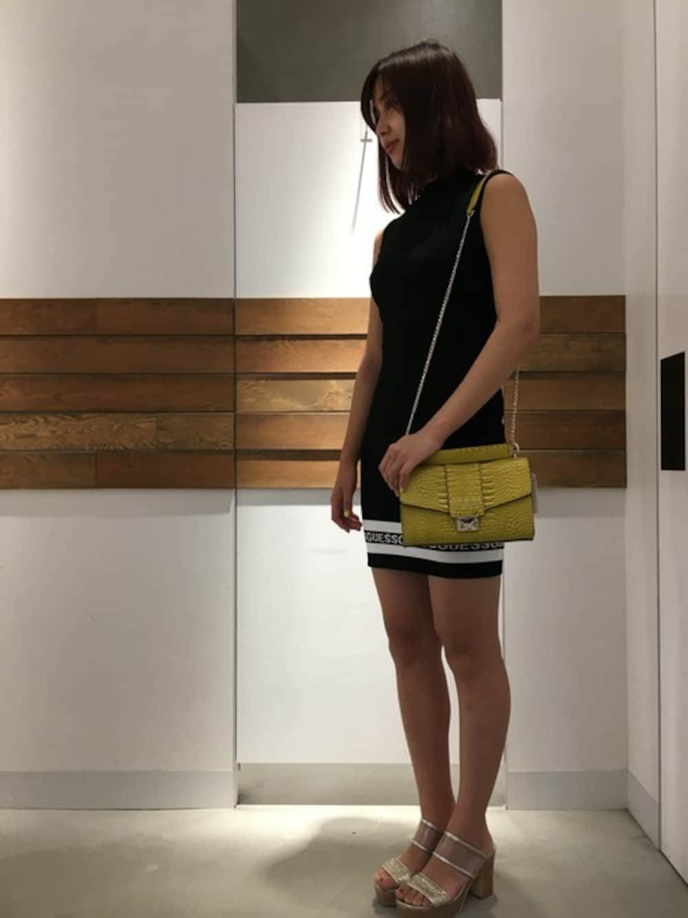 ブラック系のワンピース、イエロー系のハンドバッグを着用したレディースの夏コーディネートの1枚目の写真