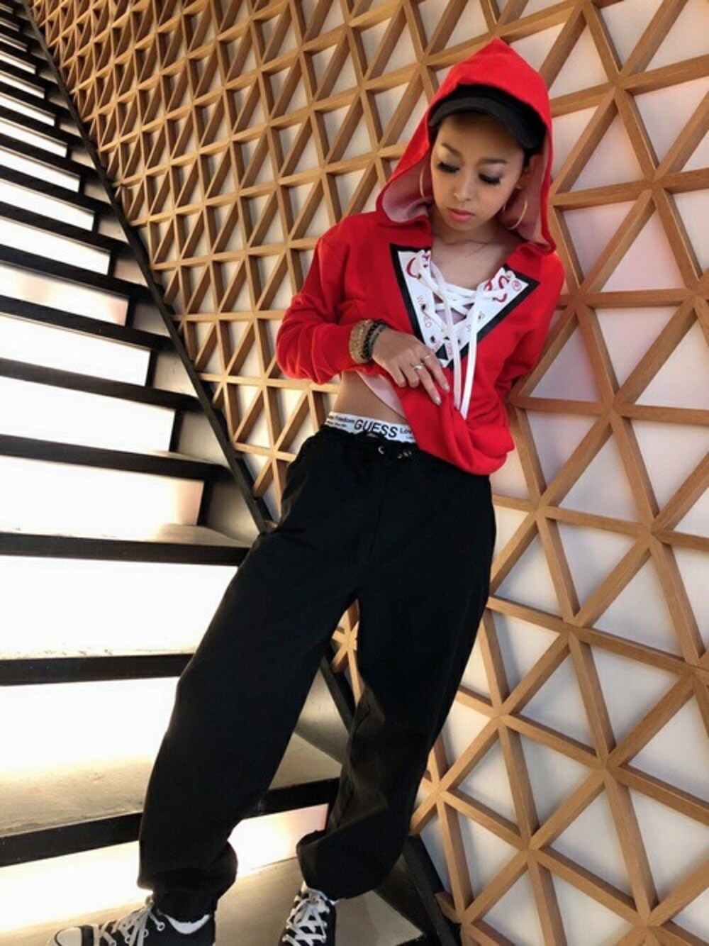 レッド系のパーカー、ブラック系のその他パンツを着用したレディースの秋コーディネートの1枚目の写真