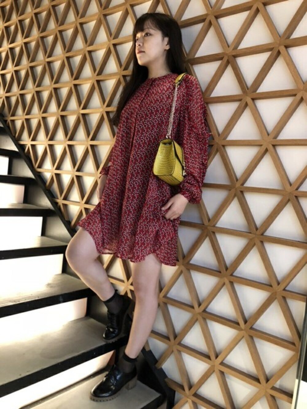 レッド系のワンピース、イエロー系のハンドバッグを着用したレディースの秋コーディネートの1枚目の写真