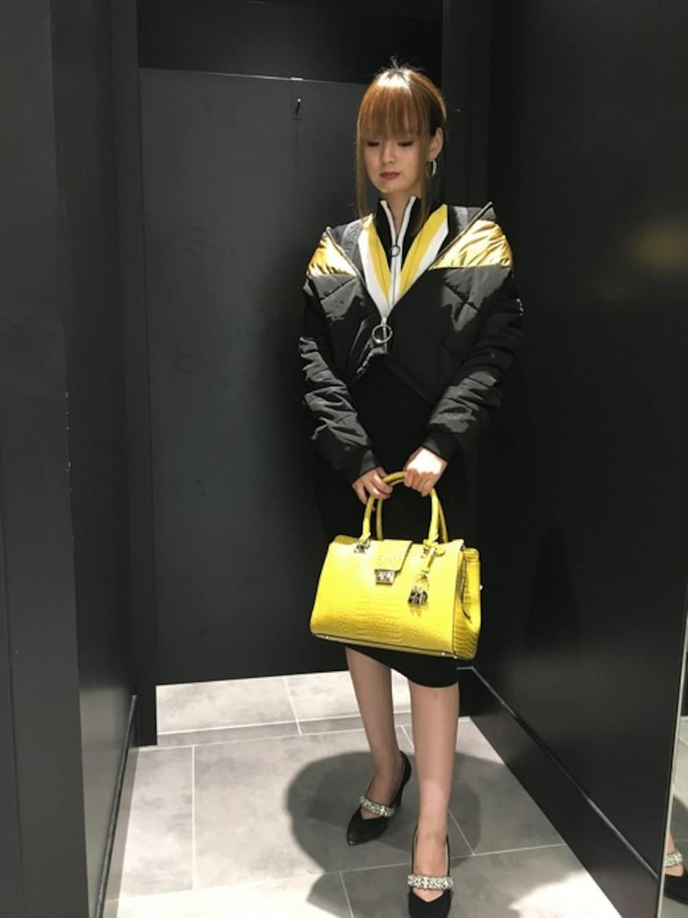 ブラック系のその他アウター、ブラック系のワンピース、イエロー系のトートバッグを着用したレディースの秋コーディネートの1枚目の写真