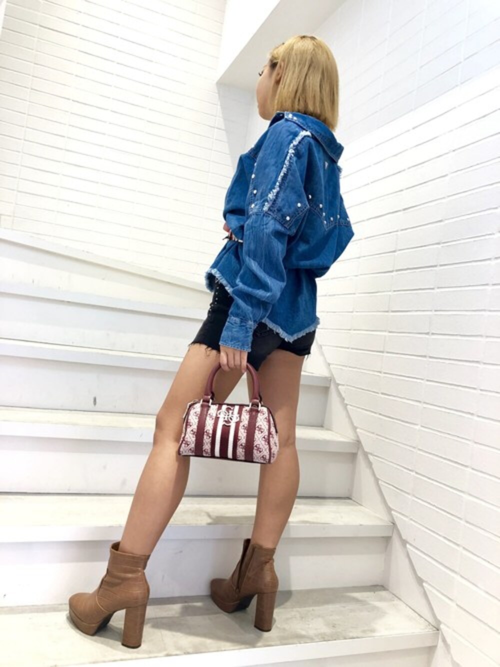 ブルー系のシャツ/ブラウス、レッド系のハンドバッグ、レッド系のベルトを着用したレディースの秋コーディネートの1枚目の写真