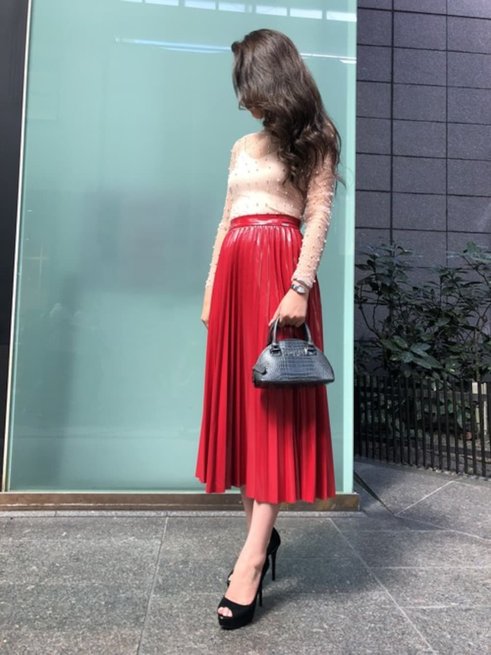 ピンク系のシャツ/ブラウス、レッド系のスカート、ブラック系のハンドバッグを着用したレディースの秋コーディネートの1枚目の写真