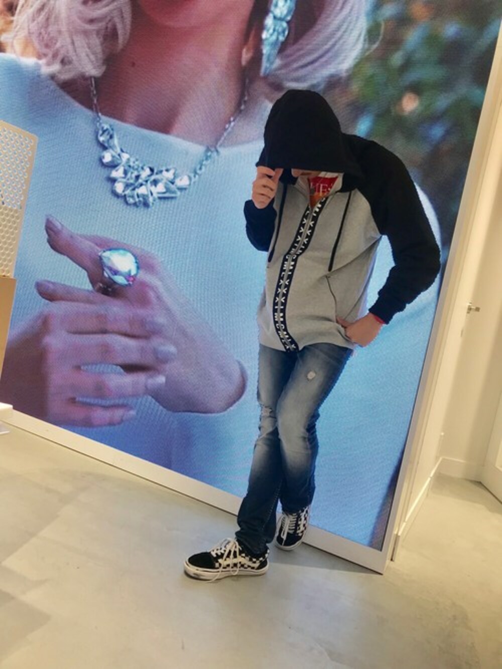 グレー系のパーカー、ブルー系のデニムパンツを着用したメンズの秋コーディネートの1枚目の写真