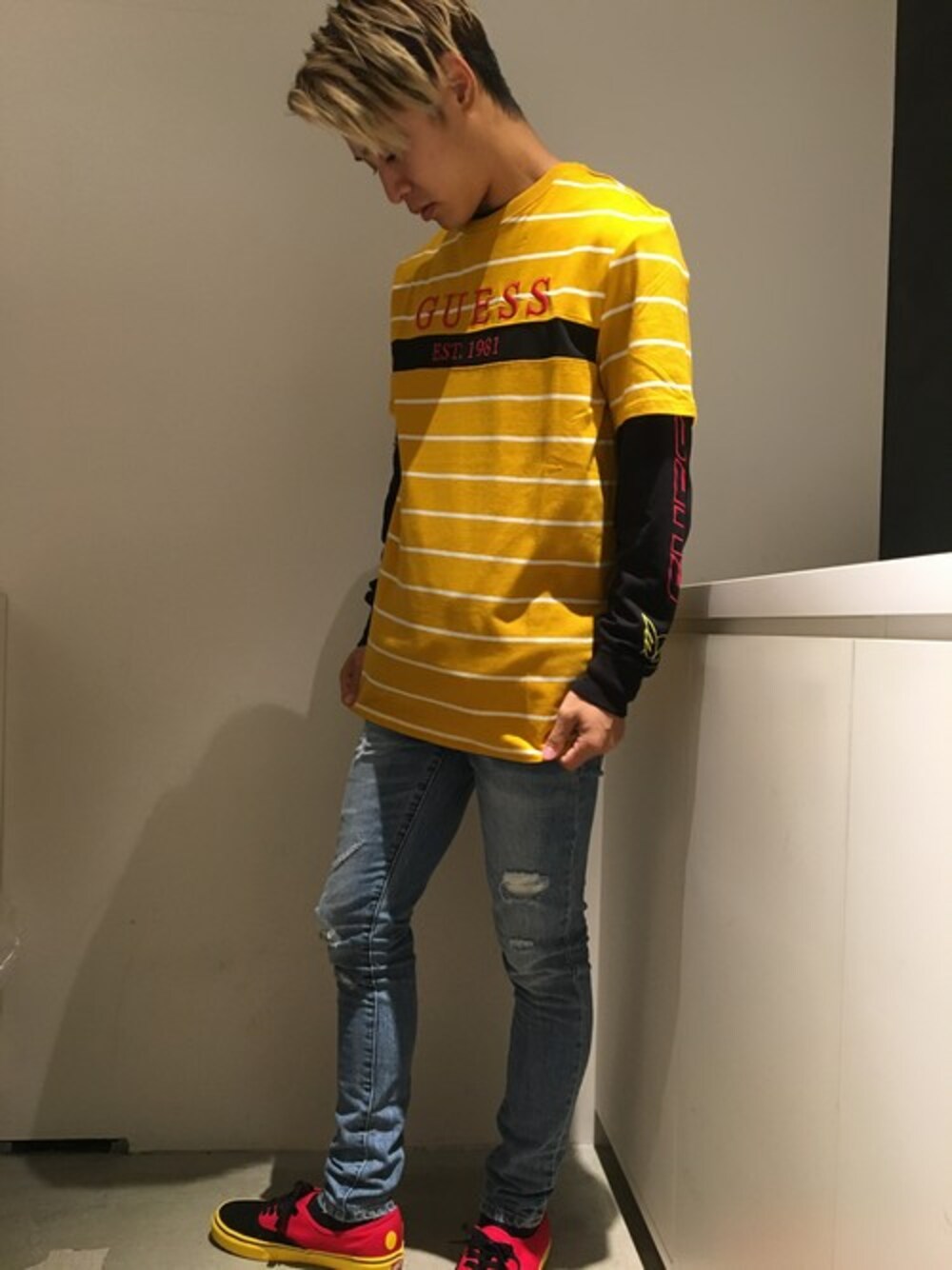 オレンジ系のTシャツ/カットソーを着用したレディースの秋コーディネートの1枚目の写真