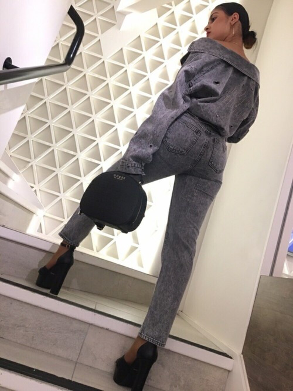 グレー系のデニムジャケット、グレー系のデニムパンツ、ブラック系のバックパック/リュックを着用したレディースの秋コーディネートの1枚目の写真