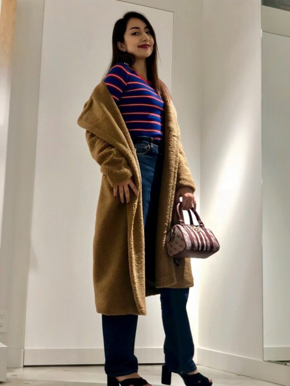 ベージュ系のその他アウター、その他のニット/セーター、ブルー系のデニムパンツを着用したレディースの秋コーディネートの1枚目の写真