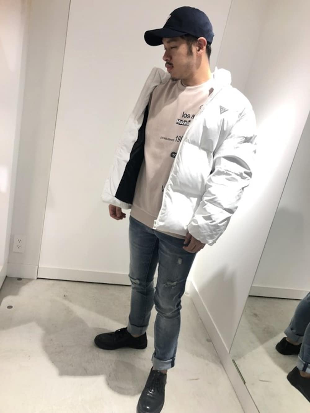 ベージュ系のスウェット、ブルー系のデニムパンツ、ブラック系のキャップを着用したメンズの秋コーディネートの1枚目の写真