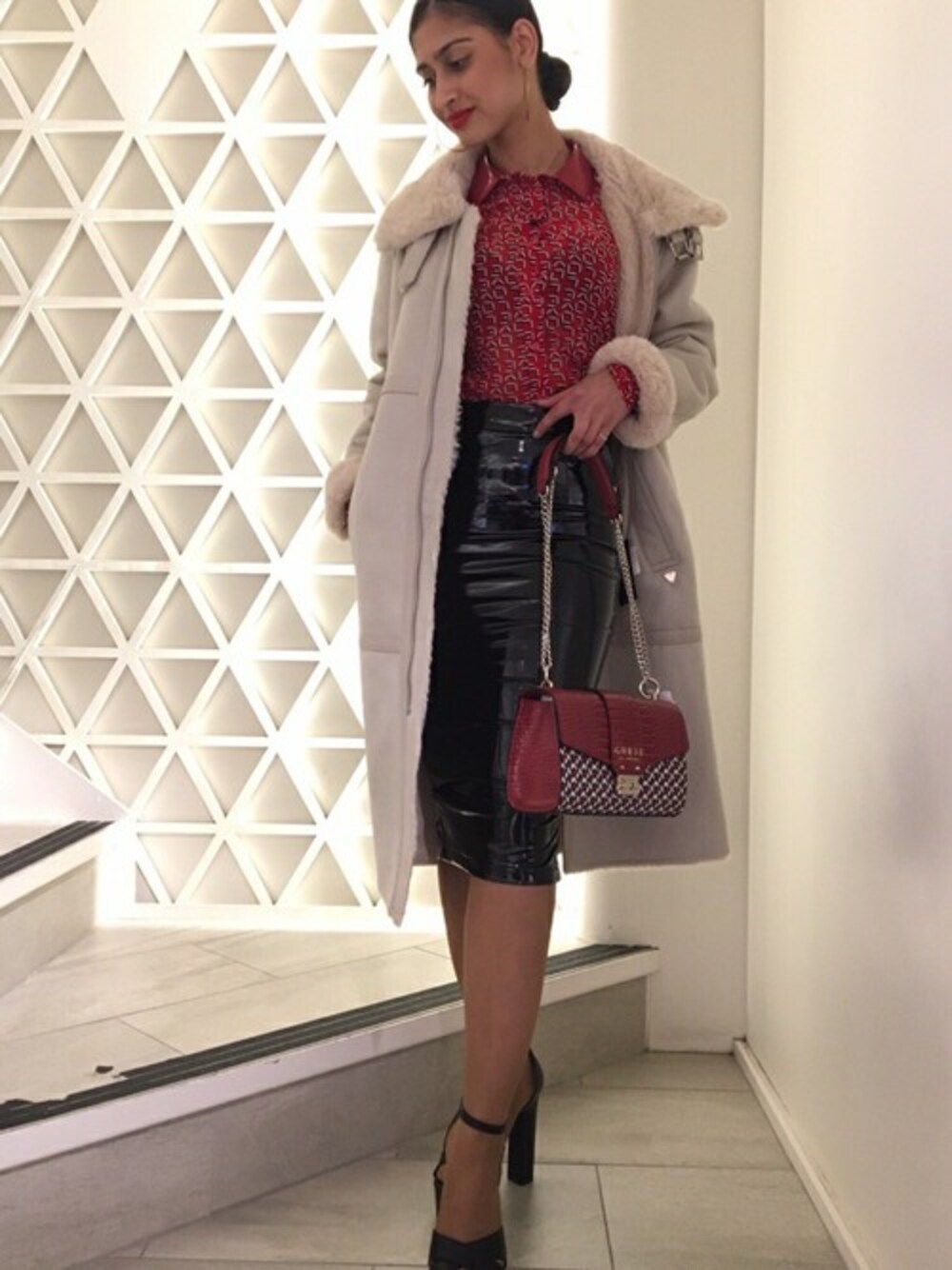 レッド系のシャツ/ブラウス、ブラック系のスカート、レッド系のハンドバッグを着用したレディースの秋コーディネートの1枚目の写真