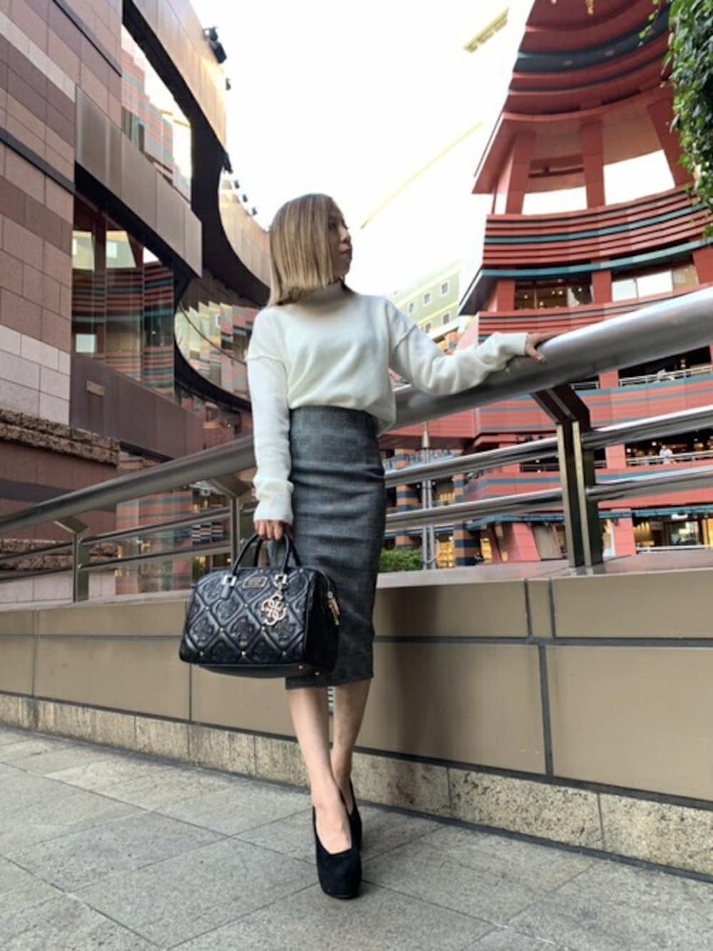 ホワイト系のニット/セーター、ブラック系のスカートを着用したレディースの秋コーディネートの1枚目の写真