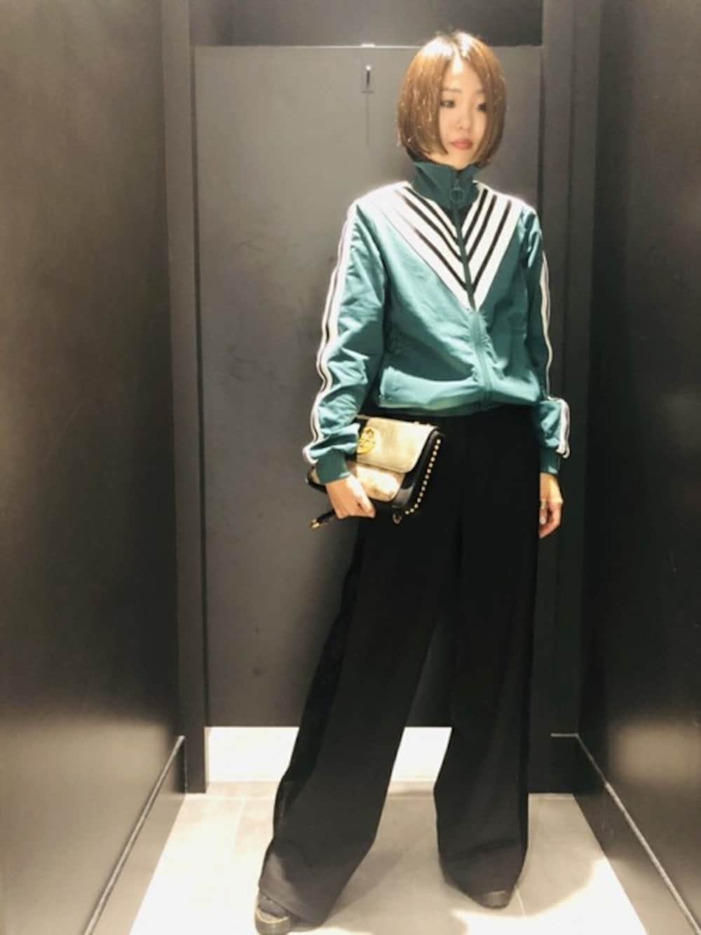 グリーン系のジャージ、ブラック系のその他パンツを着用したレディースの秋コーディネートの1枚目の写真