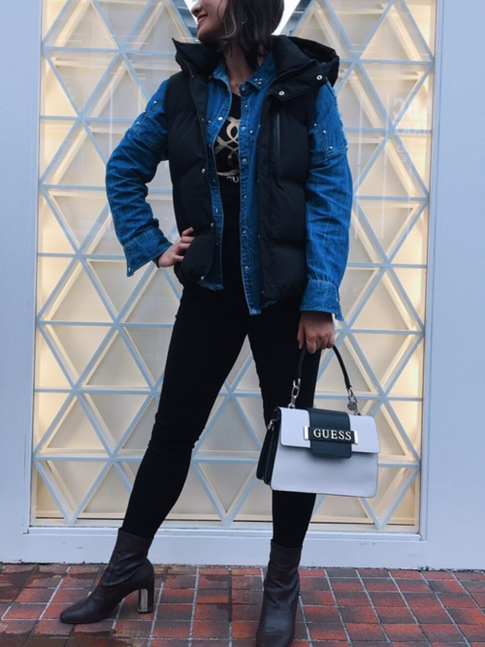 「ロゴT、カジュアル、ダウンベスト、ハンドバッグ、秋のコーデ、デニムシャツ、スポーツミックス、デニムパンツ、guess」｜「GuessのHOODED DOWN VEST（ダウンベスト、ブラック系）」を使った、GUESS JAPANさん（レディース・160cm）の秋コーディネートの1枚目の写真
