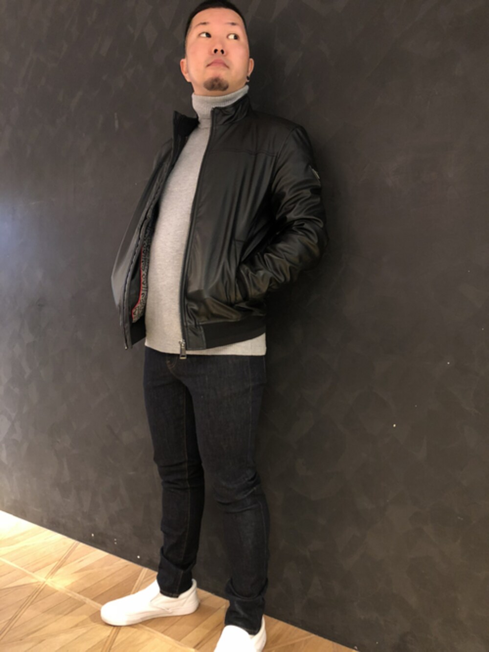 ブラック系のその他アウター、グレー系のニット/セーター、ブルー系のデニムパンツを着用したメンズの秋コーディネートの1枚目の写真