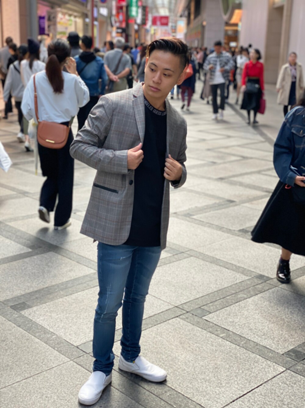 ブラック系のテーラードジャケット、ブラック系のTシャツ/カットソー、ブルー系のデニムパンツを着用したメンズの秋コーディネートの1枚目の写真