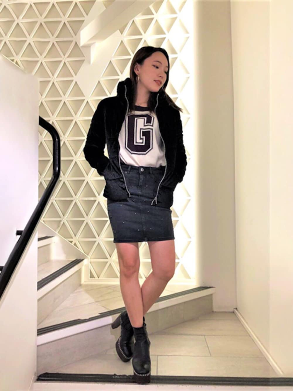 ブラック系のその他アウター、ホワイト系のニット/セーター、ブルー系のデニムスカートを着用したレディースの秋コーディネートの1枚目の写真