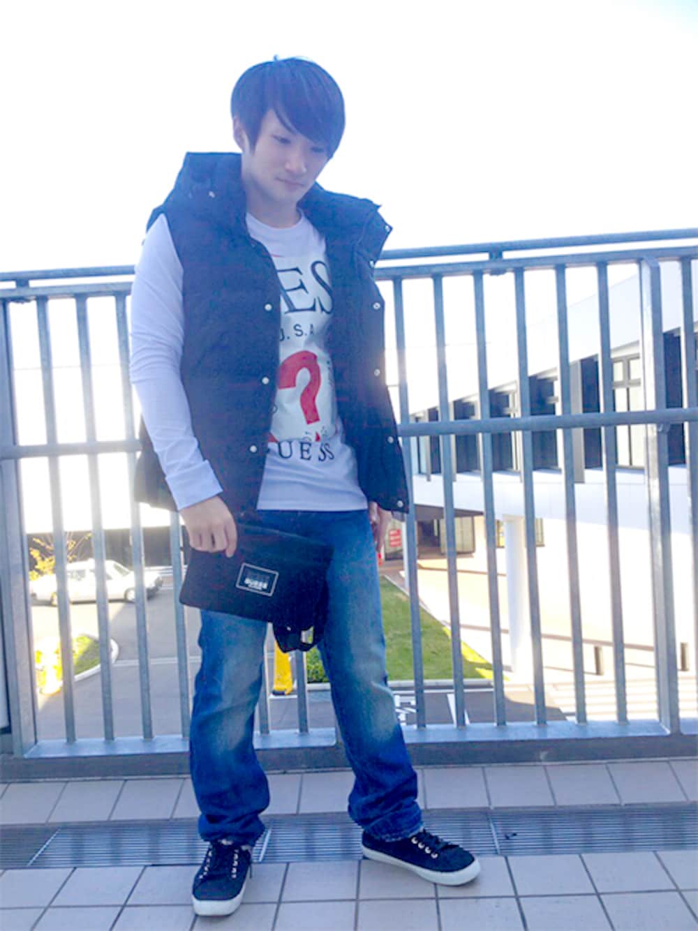 ブラック系のダウンベスト、ホワイト系のTシャツ/カットソー、ブラック系のショルダーバッグを着用したメンズの秋コーディネートの1枚目の写真