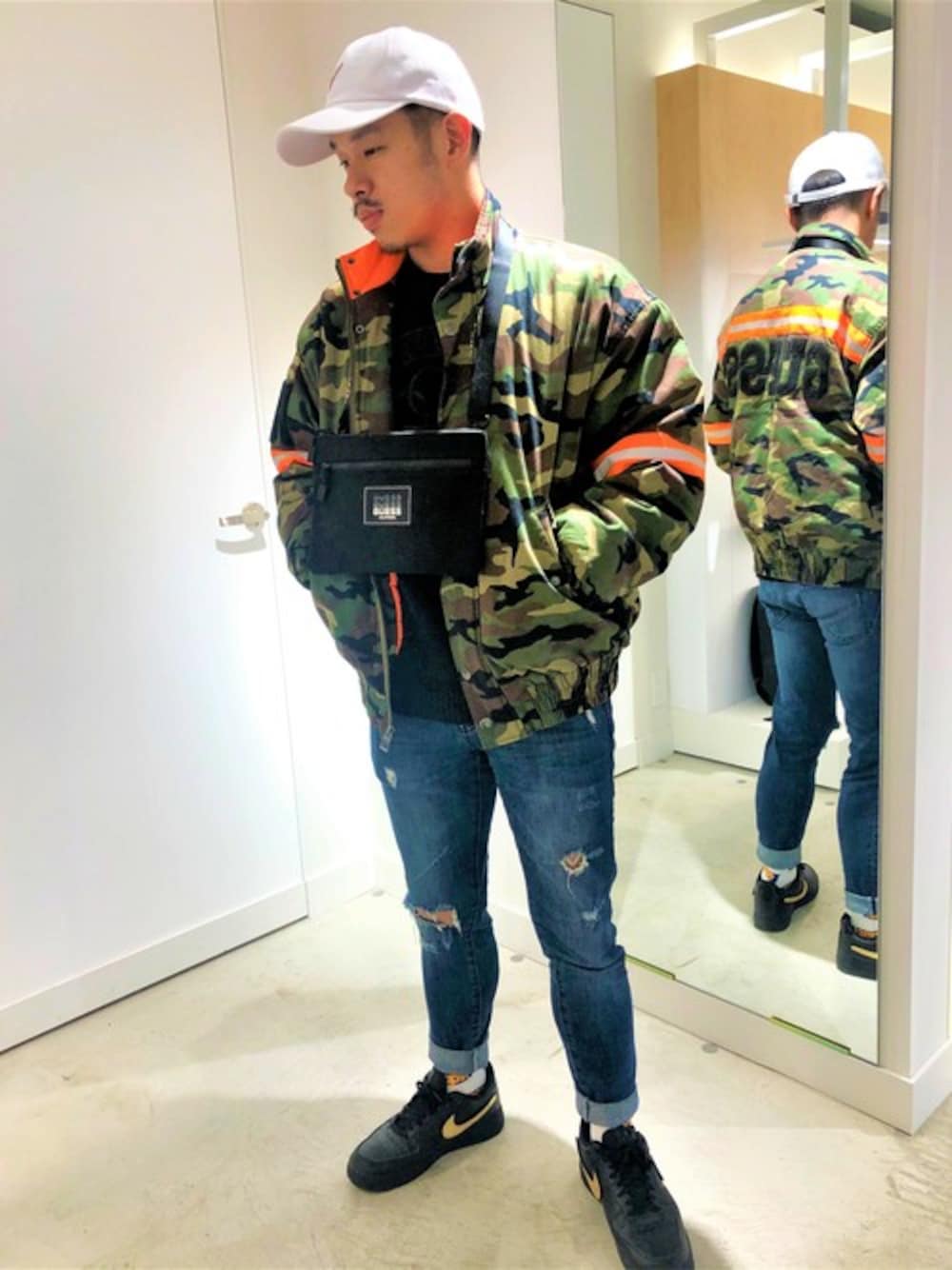 「ニット、ジャケット、カジュアル、キャップ、ストリート、迷彩、ロゴ、デニムパンツ、guess」｜「GuessのCARTER REFLECTIVE CAMO BOMBER JACKET（ブルゾン、グリーン系）」を使った、GUESS JAPANさん（メンズ・170cm）の秋コーディネートの1枚目の写真