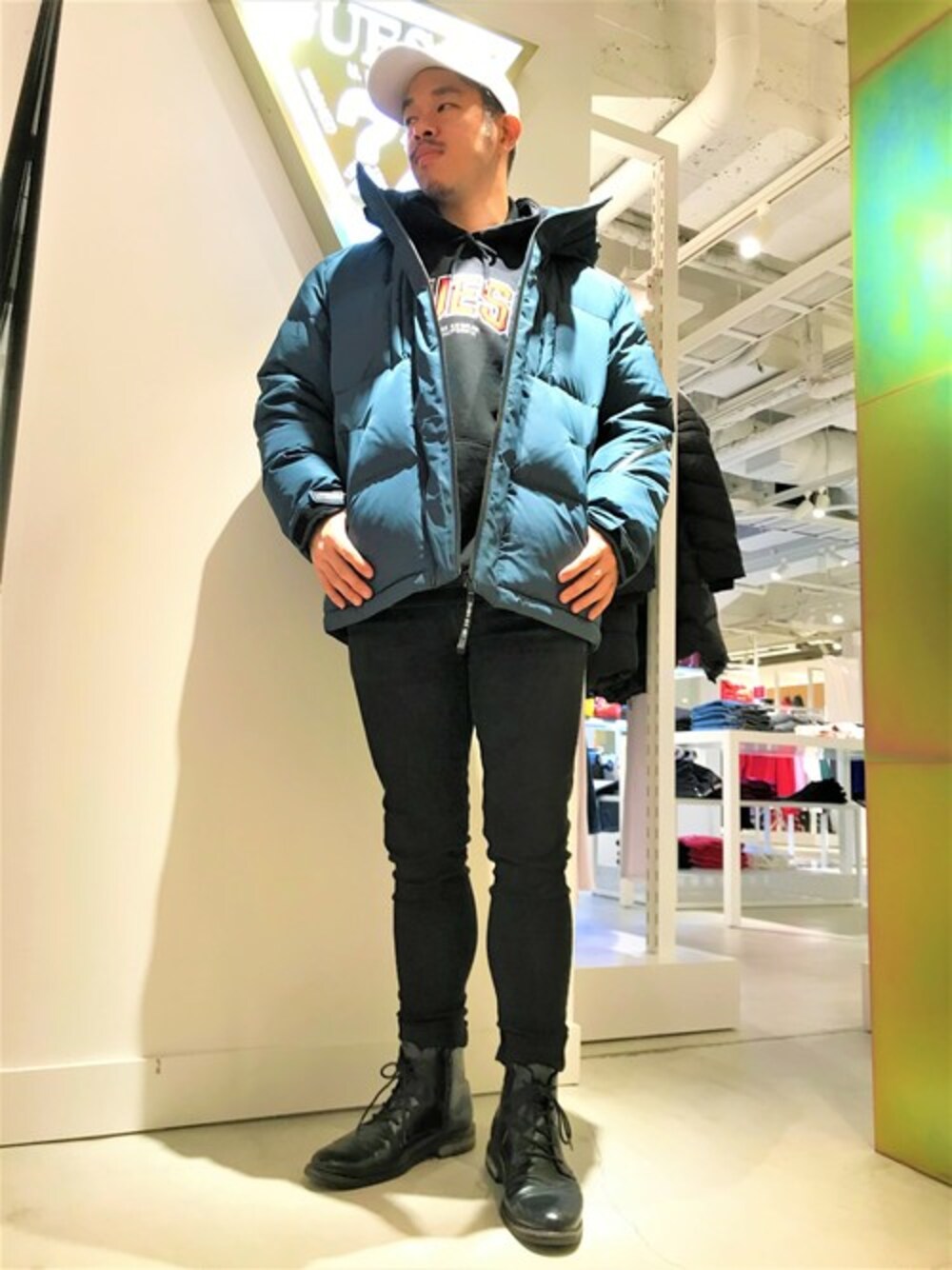 ブラック系のスウェット、ブルー系のデニムパンツ、グリーン系のダウンジャケット/コートを着用したメンズの冬コーディネートの1枚目の写真