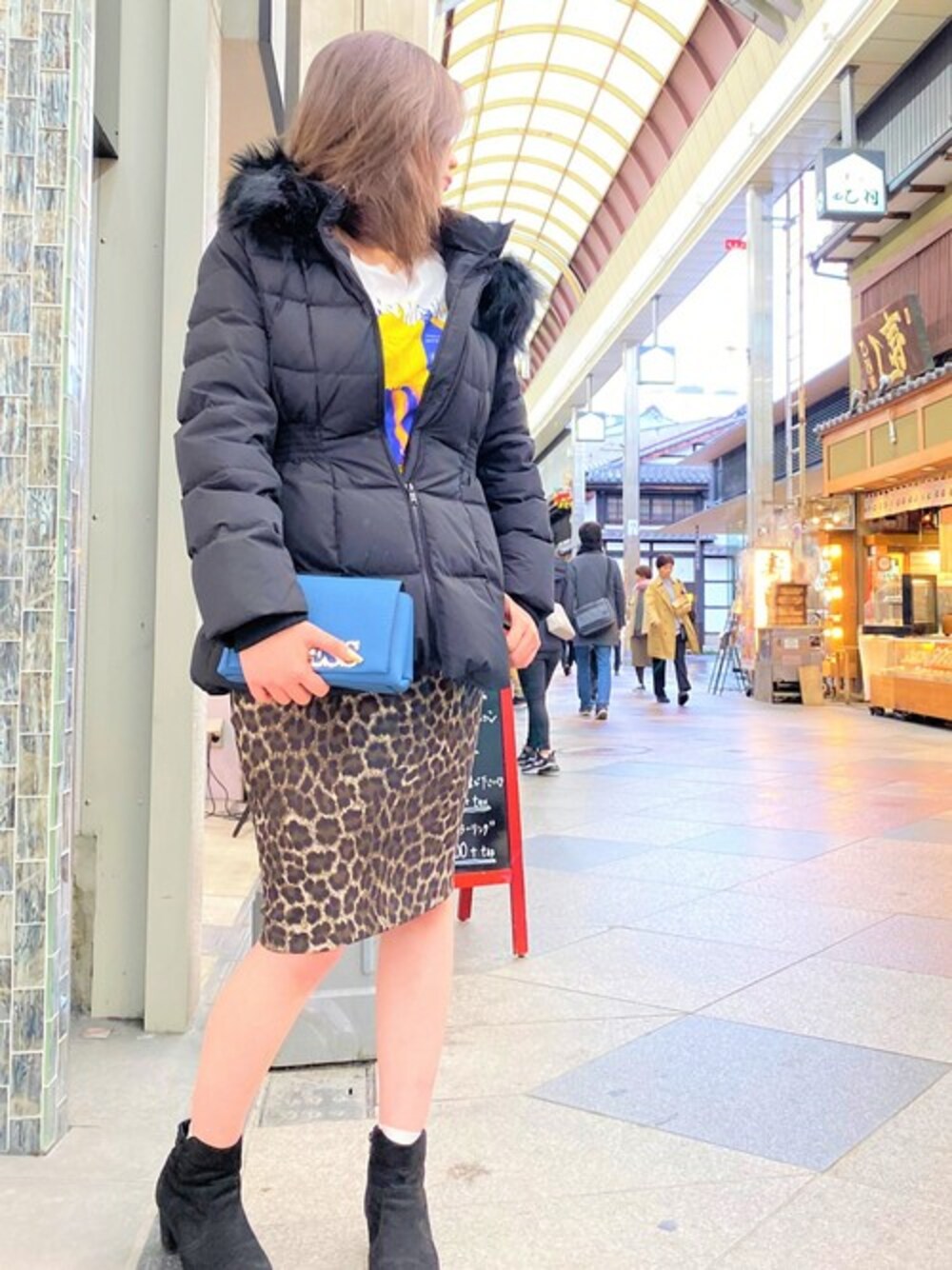 ブルー系のショルダーバッグ、ブラック系のダウンジャケット/コート、その他のスカートを着用したレディースの冬コーディネートの1枚目の写真