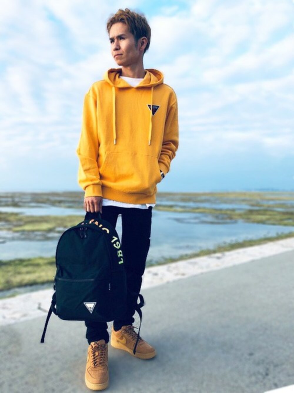 イエロー系のパーカー、ホワイト系のTシャツ/カットソーを着用したレディースの冬コーディネートの1枚目の写真