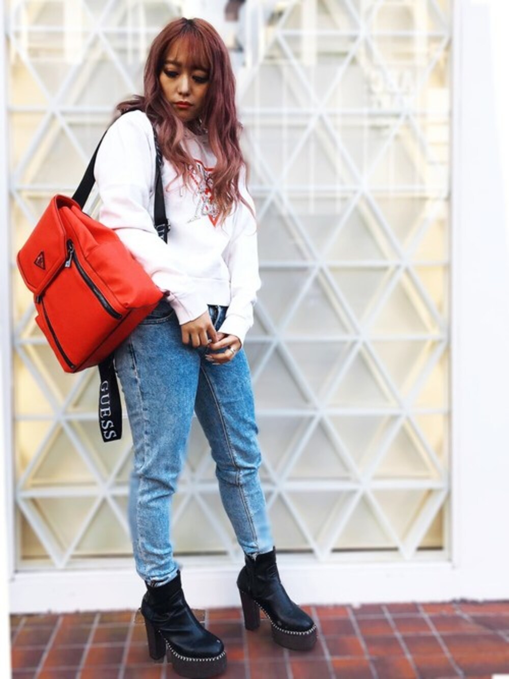 ブルー系のデニムパンツ、その他のパーカー、レッド系のバックパック/リュックを着用したレディースの冬コーディネートの1枚目の写真