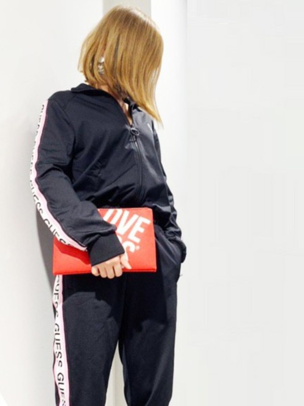 レッド系のショルダーバッグ、ブラック系のつなぎ/オールインワンを着用したレディースの冬コーディネートの1枚目の写真