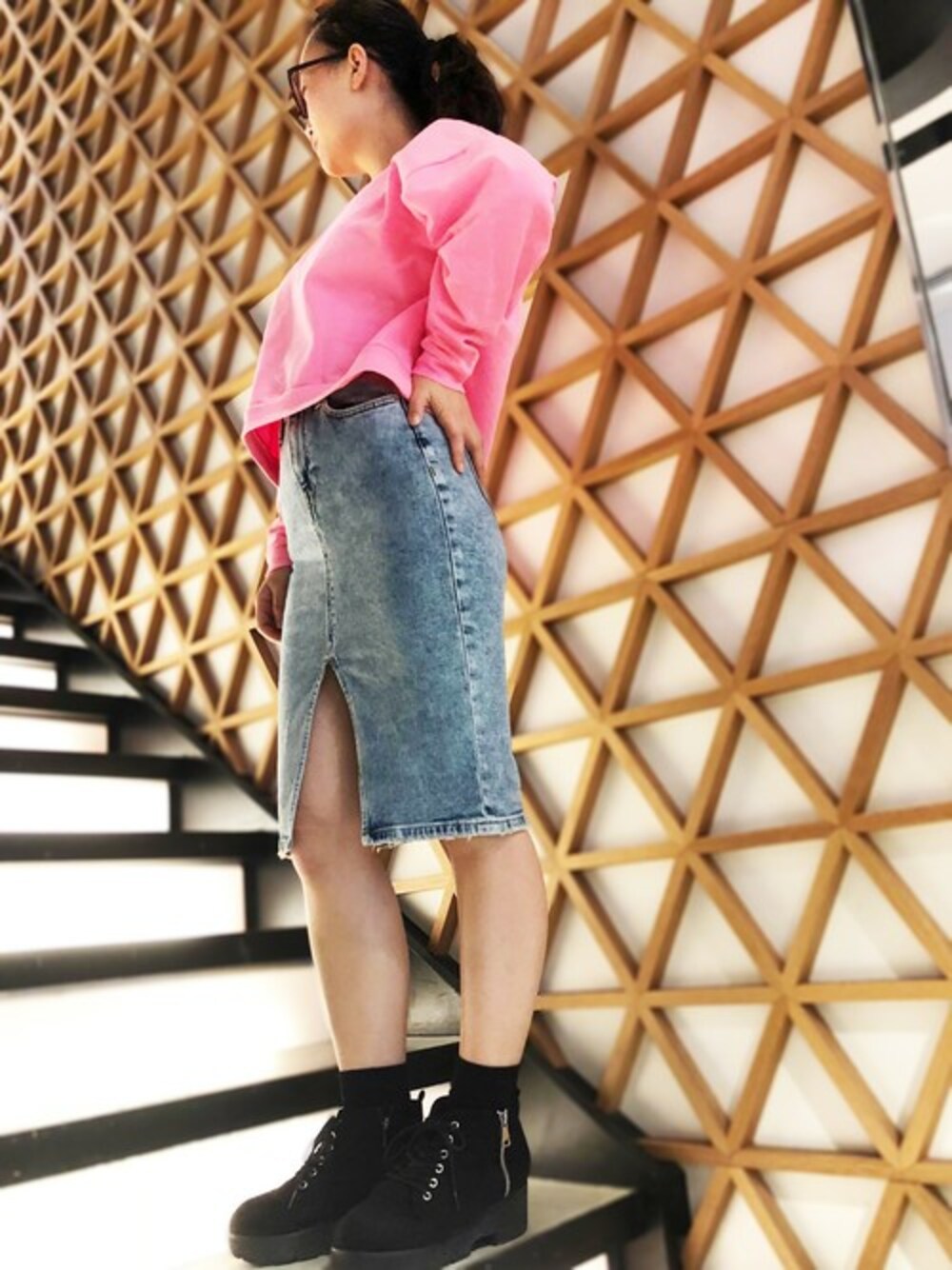 ピンク系のスウェット、ブルー系のデニムスカートを着用したレディースの冬コーディネートの1枚目の写真