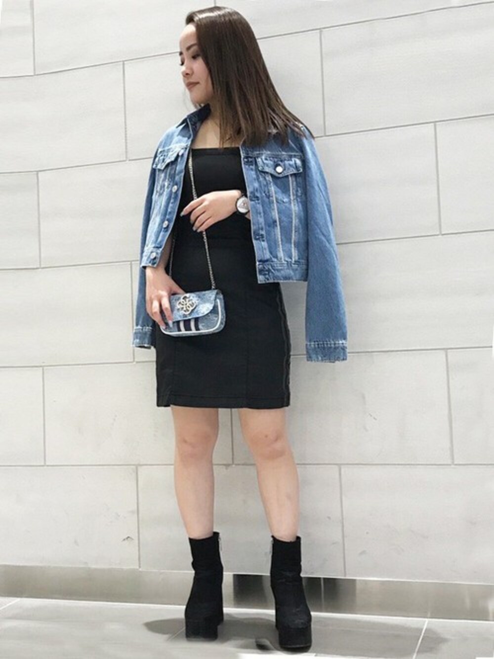 ブルー系のデニムジャケット、ブルー系のショルダーバッグを着用したレディースの春コーディネートの1枚目の写真