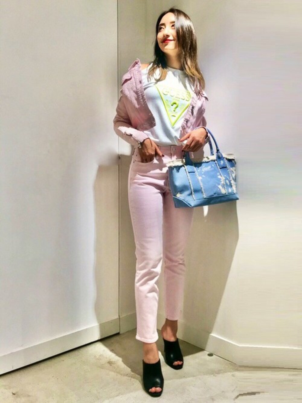 ブルー系のトートバッグ、ホワイト系のニット/セーター、ピンク系のデニムジャケットを着用したレディースの春コーディネートの1枚目の写真