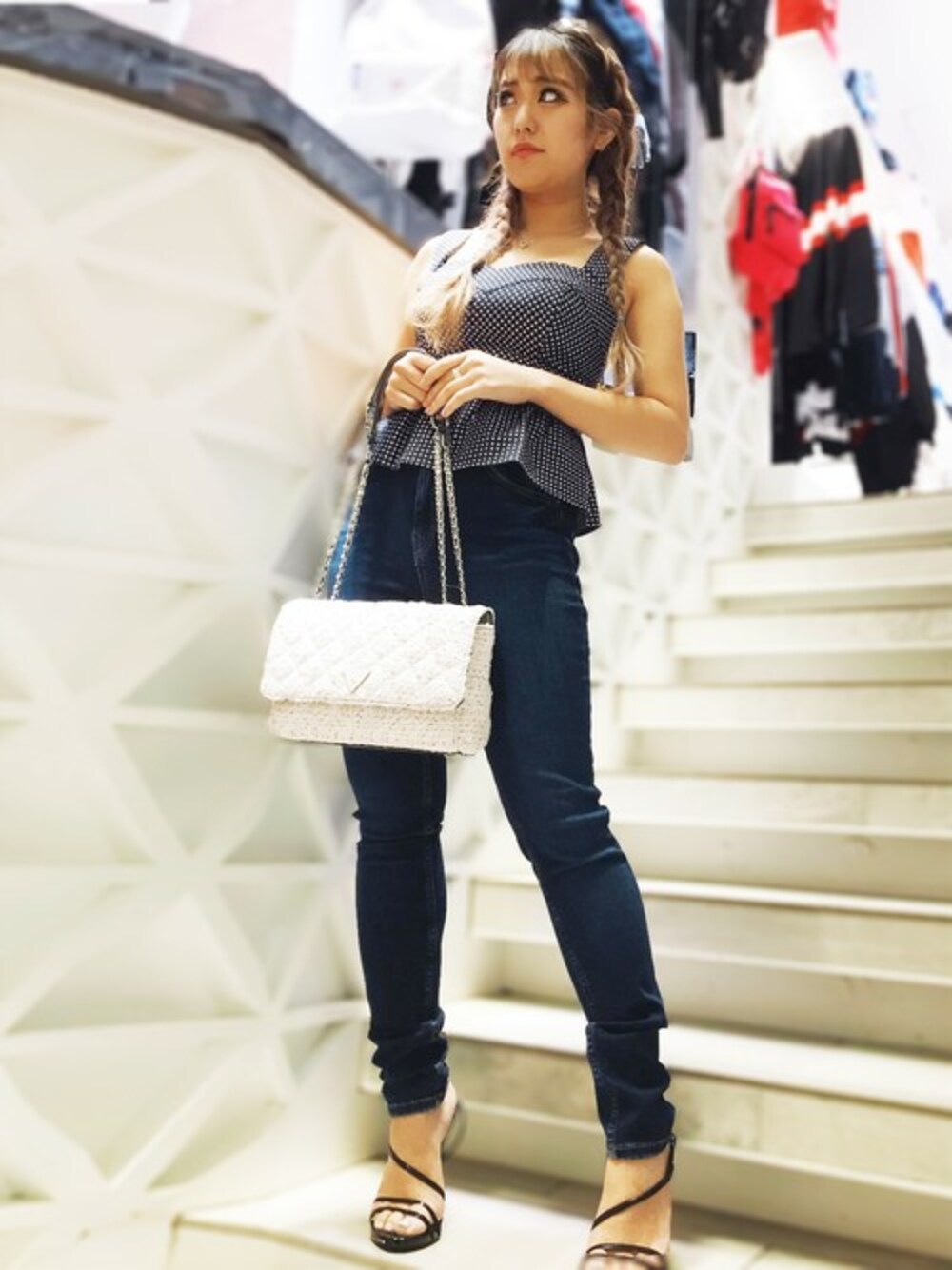 ブラック系のキャミソール、ブルー系のデニムパンツ、ホワイト系のハンドバッグを着用したレディースの春コーディネートの1枚目の写真