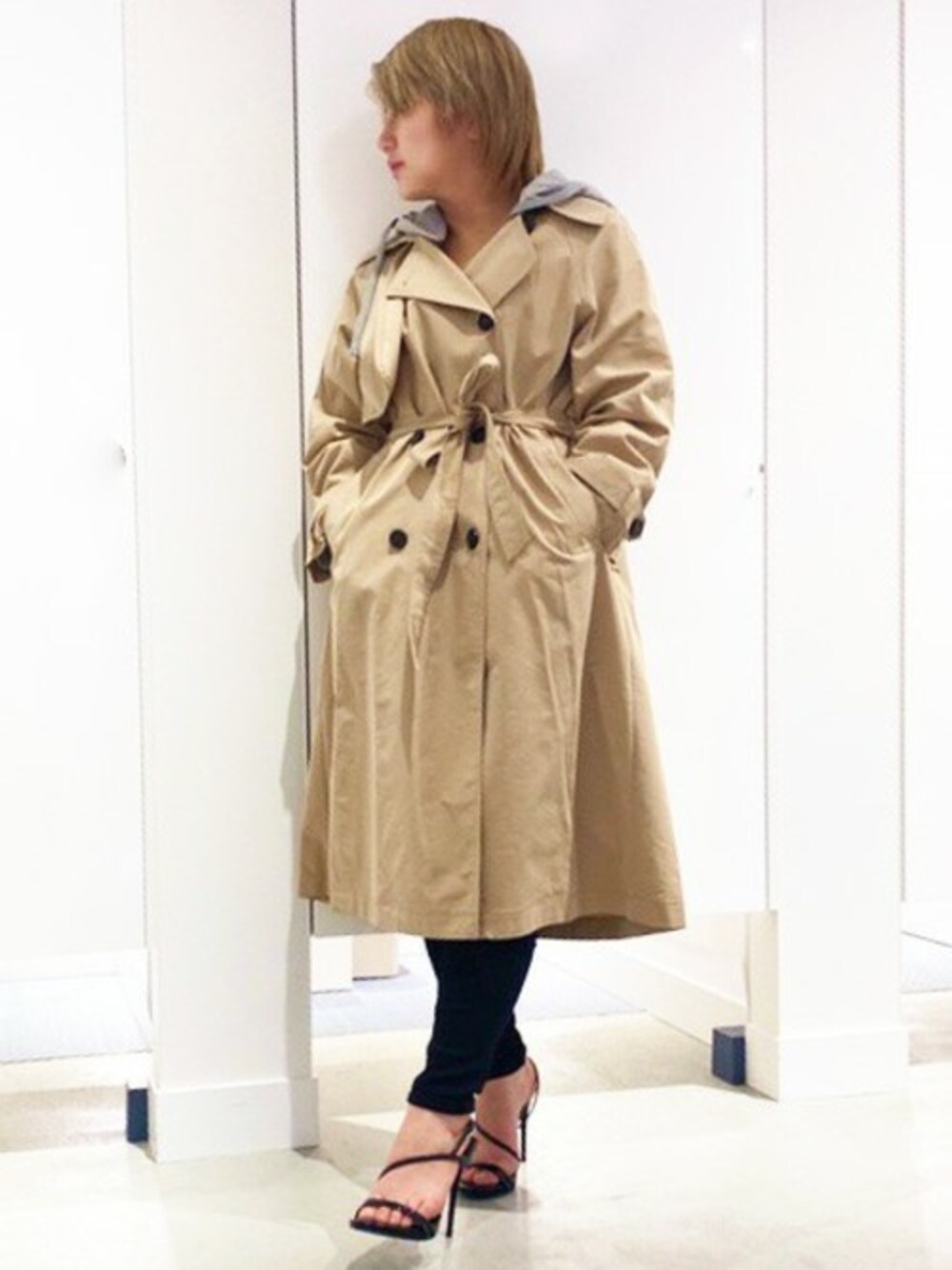 ブラック系のデニムパンツ、ベージュ系のトレンチコートを着用したレディースの春コーディネートの1枚目の写真