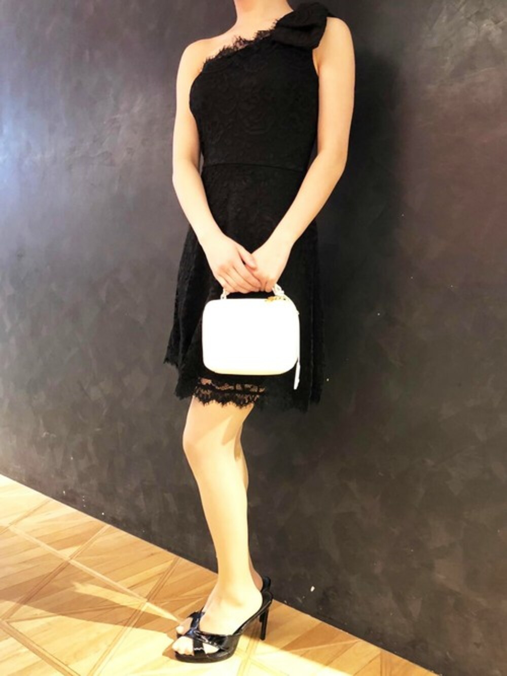 ブラック系のドレス、ブラック系のショルダーバッグを着用したレディースの春コーディネートの1枚目の写真