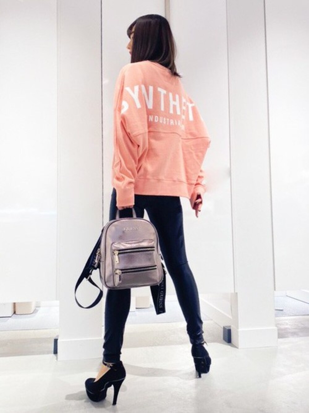 ピンク系のスウェット、ピンク系のバックパック/リュック、ブラック系のレギンス/スパッツを着用したレディースの春コーディネートの1枚目の写真