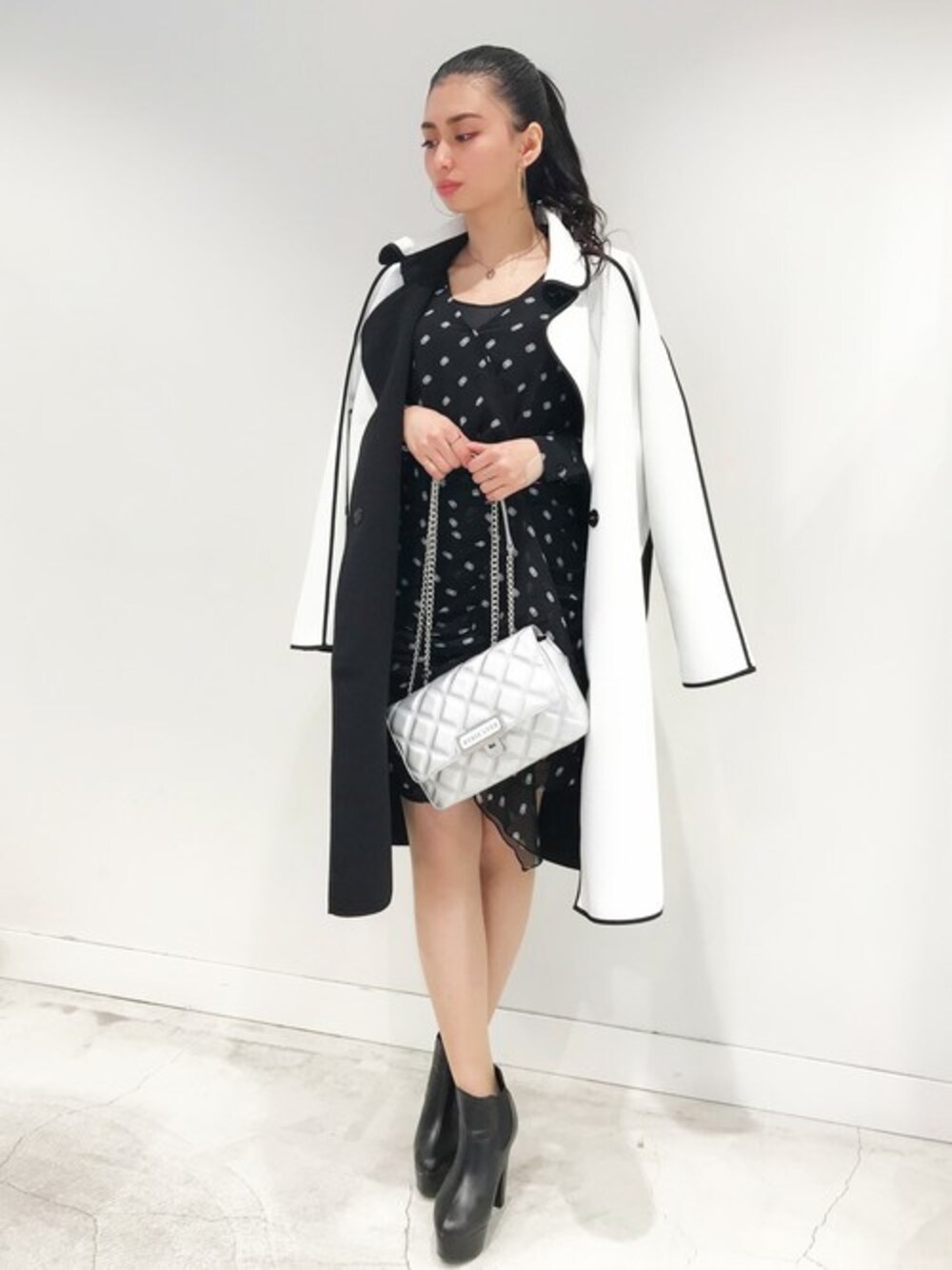 ホワイト系のその他アウター、ブラック系のワンピース、ホワイト系のショルダーバッグを着用したレディースの春コーディネートの1枚目の写真