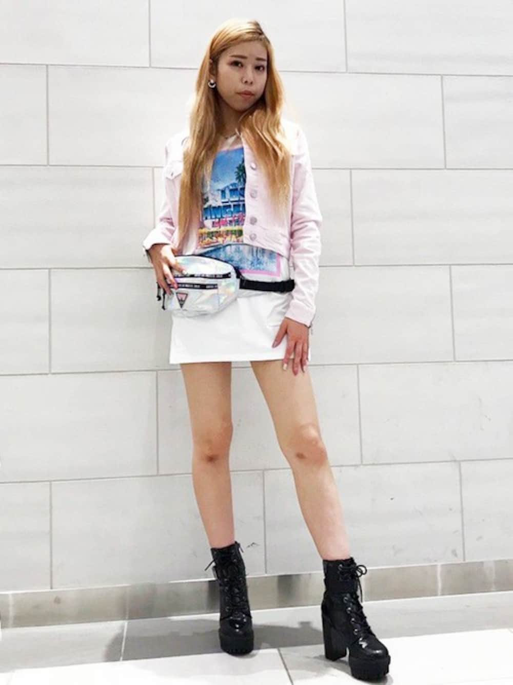 ピンク系のデニムジャケット、ブラック系のボディバッグ/ウエストポーチ、ホワイト系のTシャツ/カットソーを着用したレディースの春コーディネートの1枚目の写真