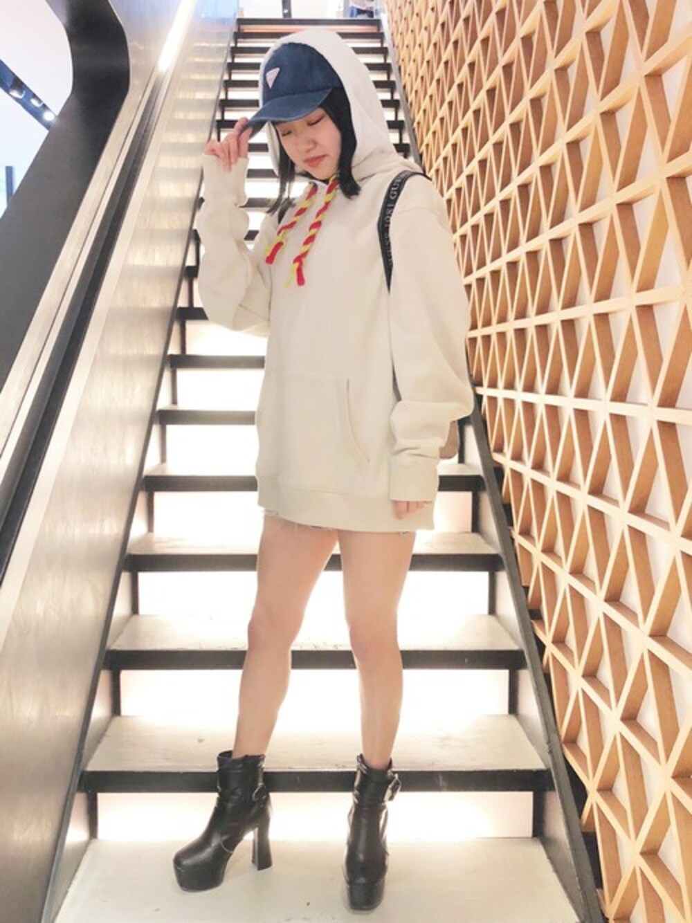 ホワイト系のパーカー、ブルー系のデニムパンツ、ピンク系のバックパック/リュックを着用したレディースの春コーディネートの1枚目の写真