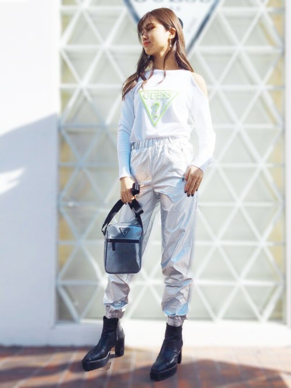 シルバー系のその他パンツ、ホワイト系のニット/セーター、グレー系のショルダーバッグを着用したレディースの春コーディネートの1枚目の写真