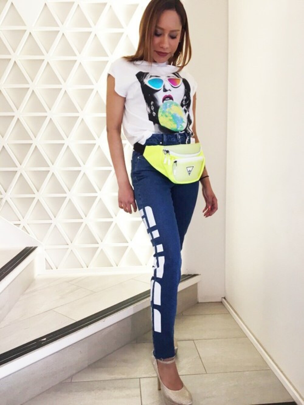 ブルー系のデニムパンツ、グリーン系のボディバッグ/ウエストポーチを着用したレディースの春コーディネートの1枚目の写真