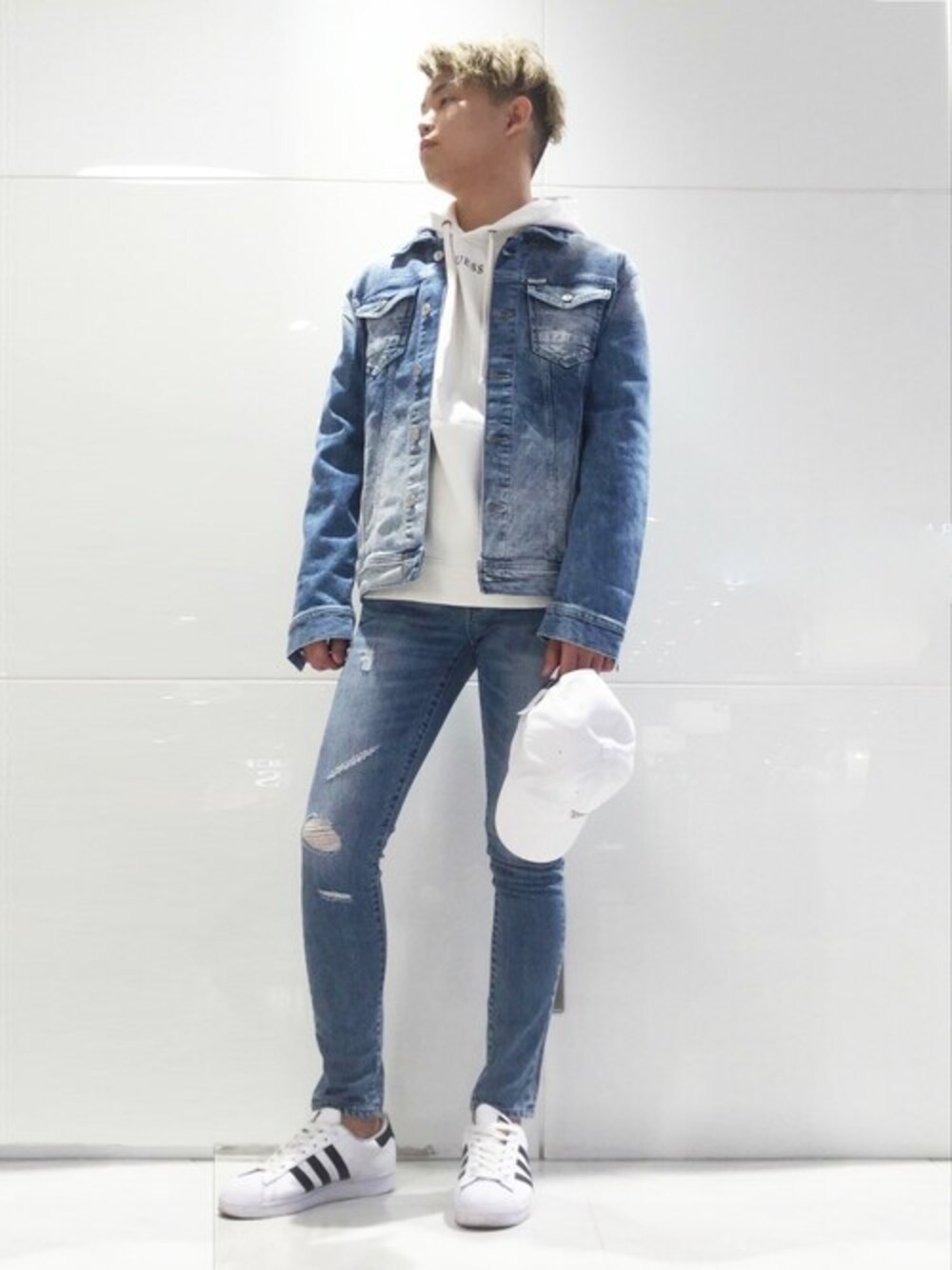 ホワイト系のパーカー、ブルー系のデニムジャケットを着用したメンズの春コーディネートの1枚目の写真