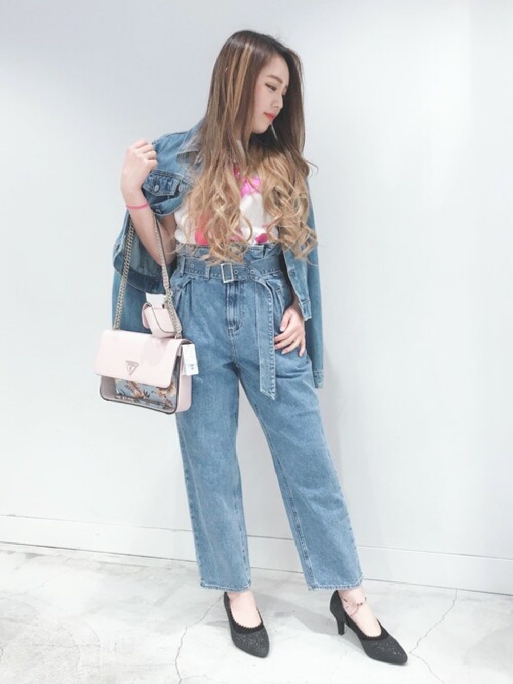 ブルー系のデニムジャケット、ピンク系のショルダーバッグ、ブルー系のデニムパンツを着用したレディースの夏コーディネートの1枚目の写真