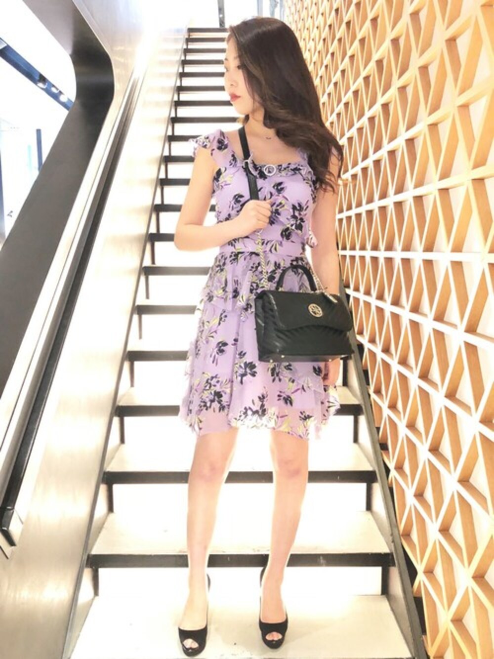 ブラック系のハンドバッグ、パープル系のワンピースを着用したレディースの夏コーディネートの1枚目の写真