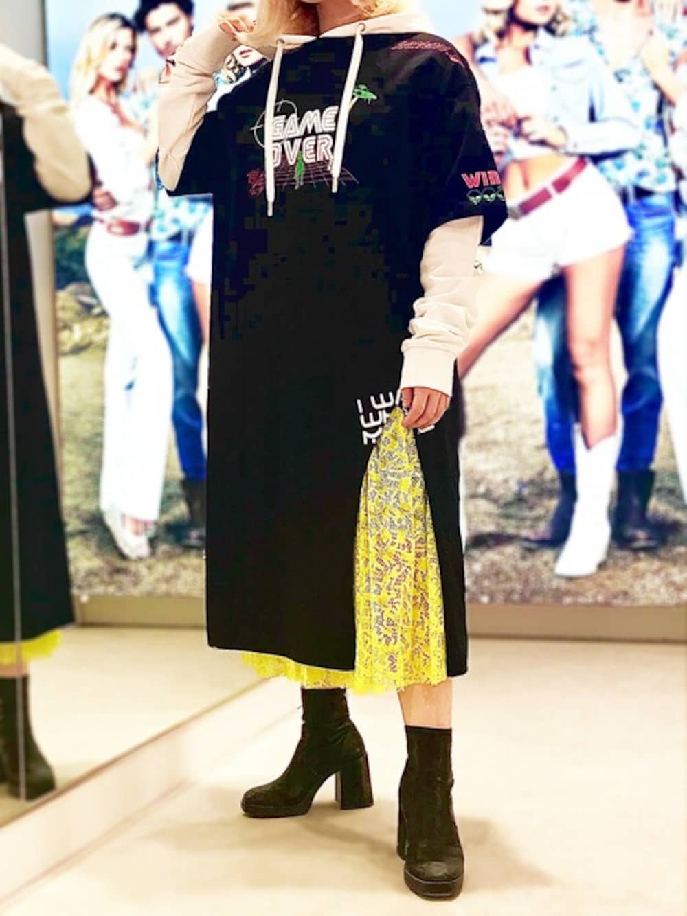 イエロー系のスカート、ホワイト系のパーカーを着用したレディースの夏コーディネートの1枚目の写真