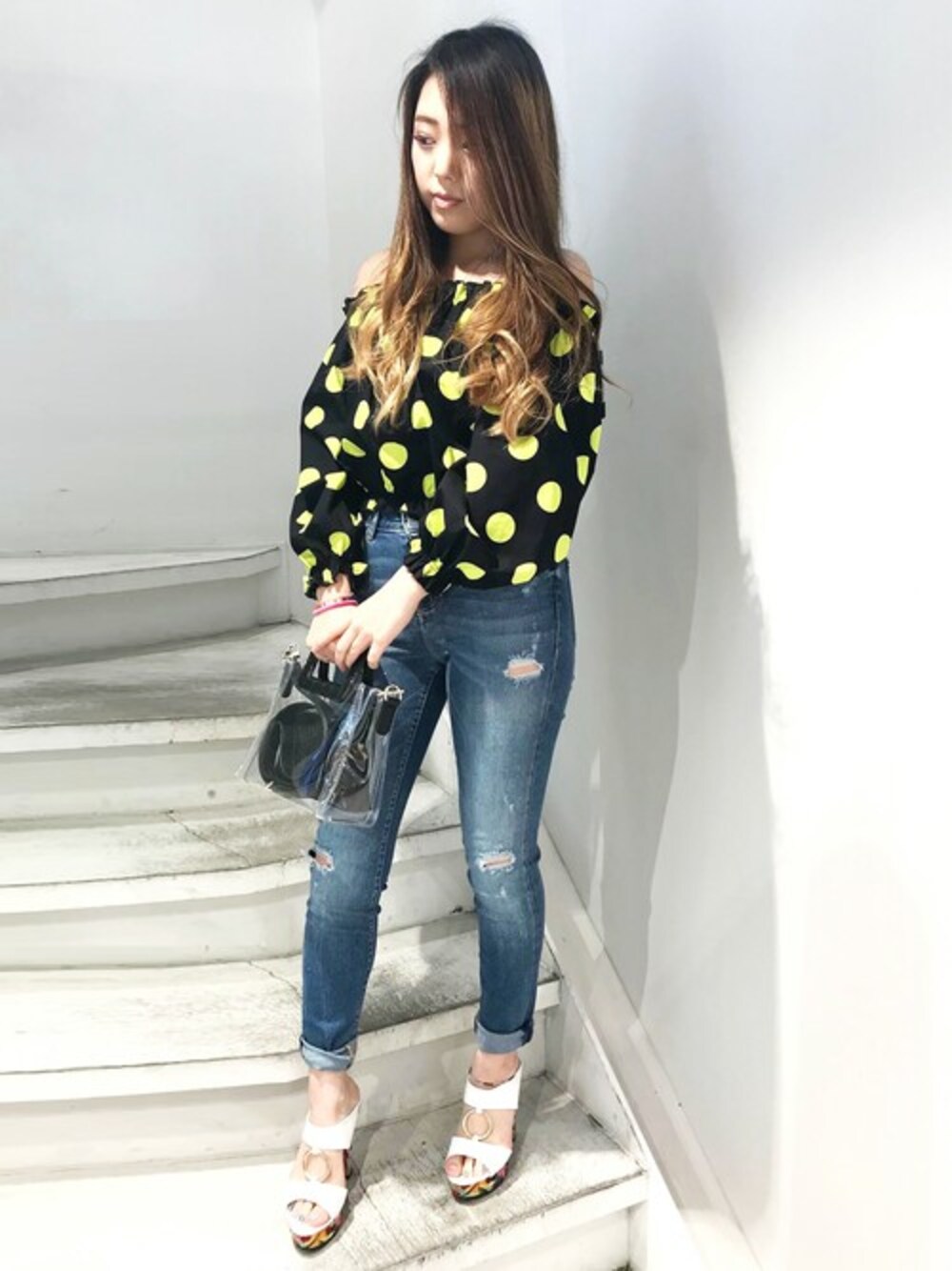 ブルー系のデニムパンツ、ブラック系のトートバッグを着用したレディースの夏コーディネートの1枚目の写真