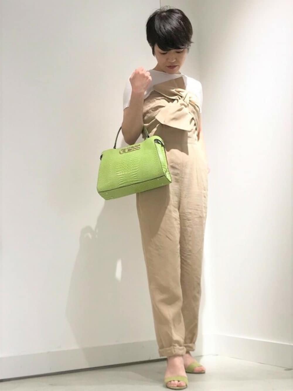 ホワイト系のTシャツ/カットソー、ベージュ系のサロペット/オーバーオール、グリーン系のショルダーバッグを着用したレディースの秋コーディネートの1枚目の写真