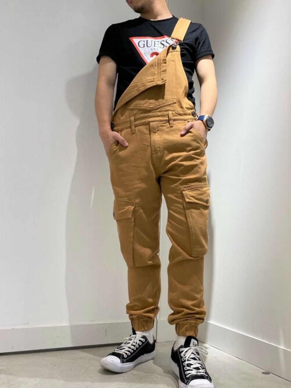 ブラック系のTシャツ/カットソー、ベージュ系のサロペット/オーバーオールを着用したメンズの秋コーディネートの1枚目の写真