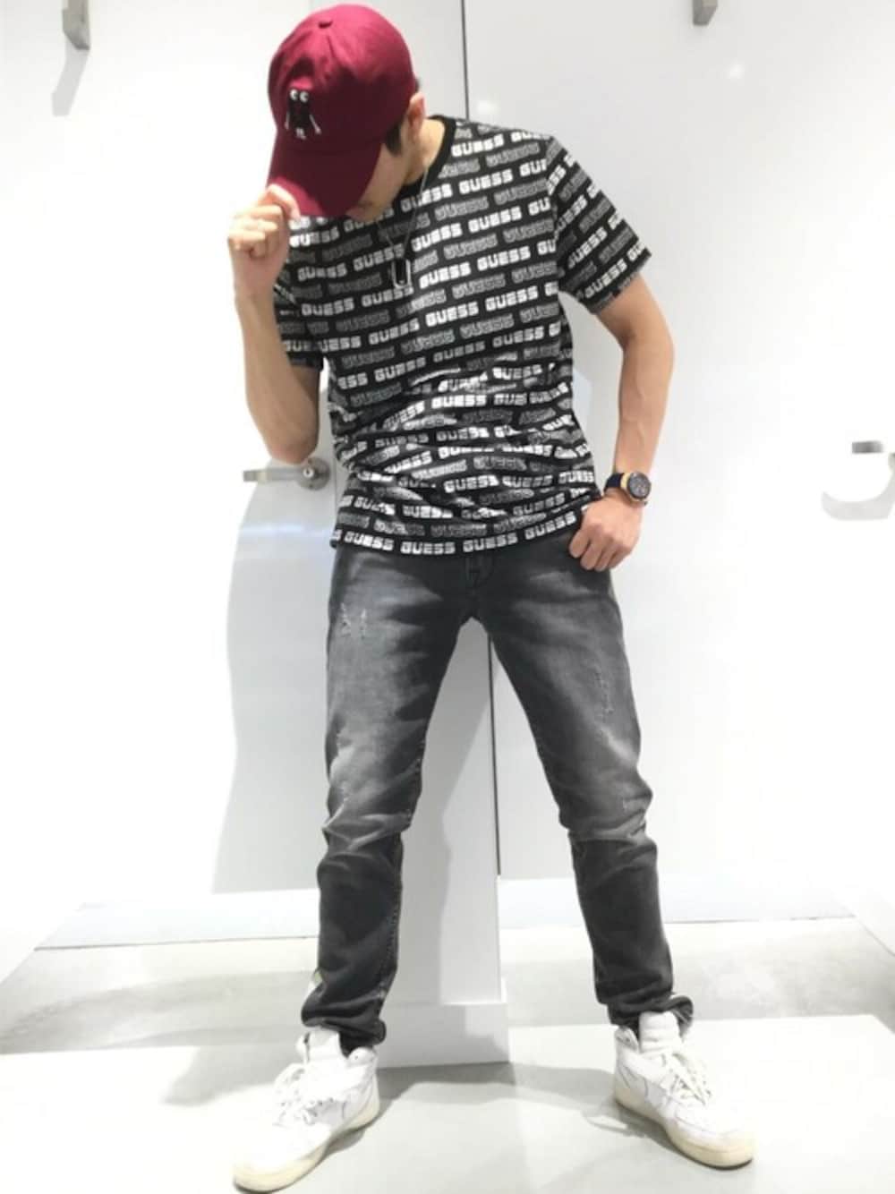 ブラック系のデニムパンツ、レッド系のキャップを着用したメンズの秋コーディネートの1枚目の写真